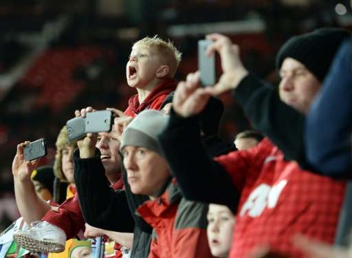 Supporters filmant un match de football