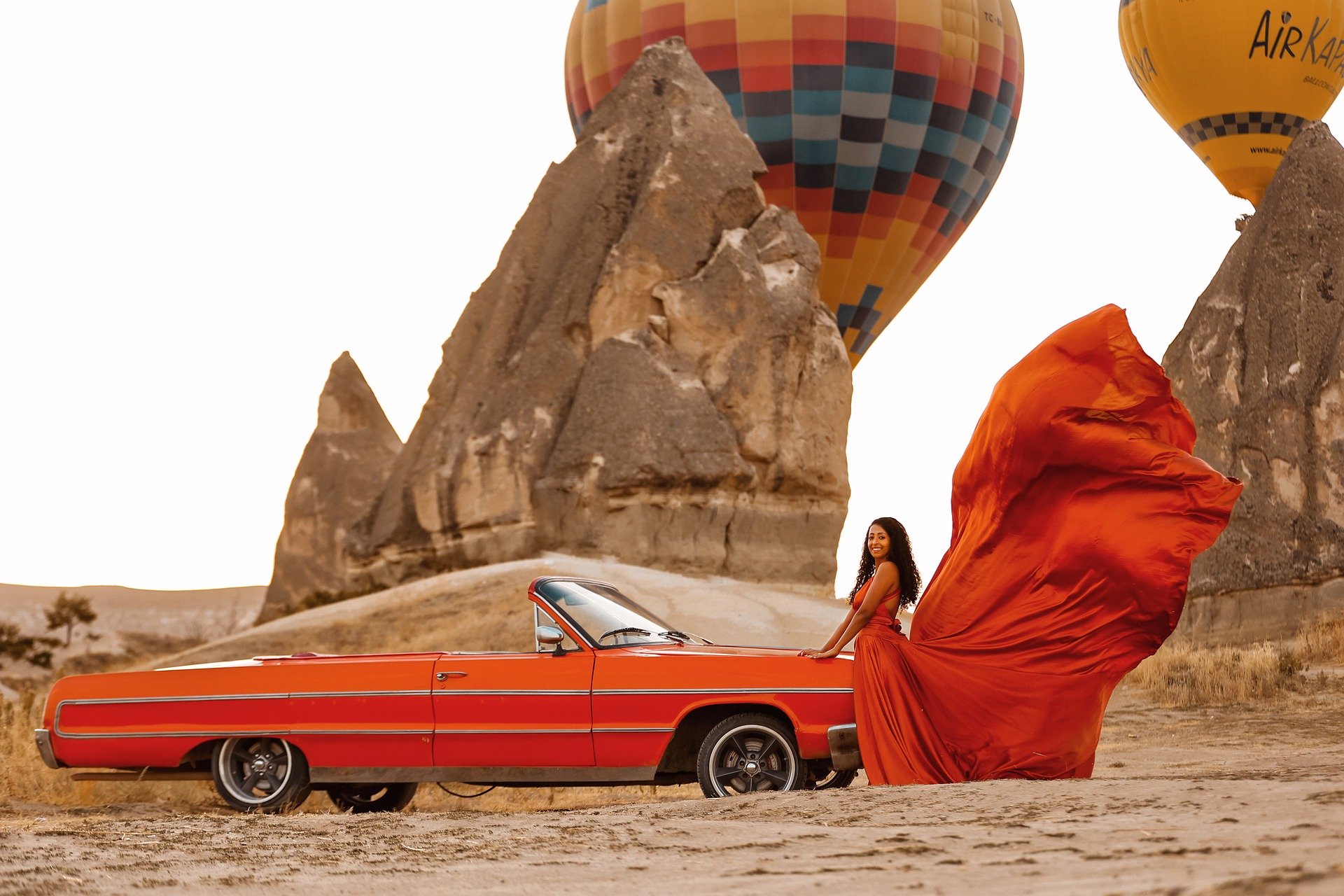 Femme élégante près d’une voiture classique dans le désert